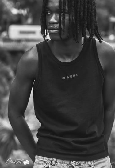 Portrait en noir et blanc d'un jeune homme avec des dreadlocks portant un débardeur à Perpignan 66.