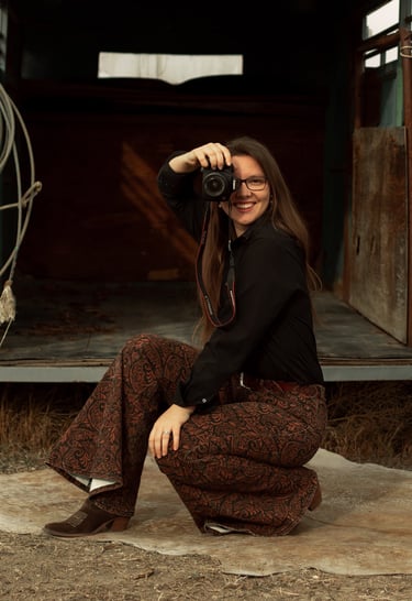 woman in western theme holding a camera up to her face