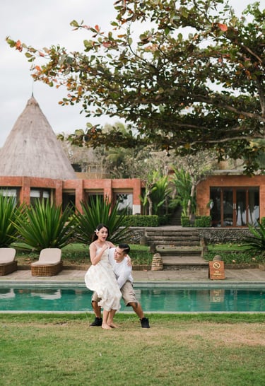 Couple standing by the pool at Waka Gangga Tabanan surrounded by tropical architecture in West Bali