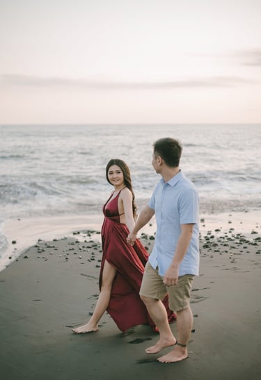 Couple walking side by side on the shoreline during sunset at Pantai Nyanyi Bali.