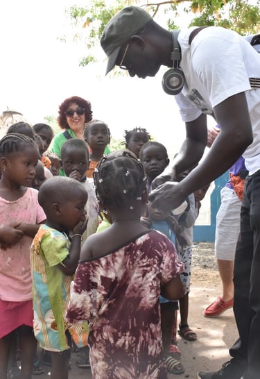 Dahomey African Tours Guide leading Tourists and giving gifts to Children in Senegal