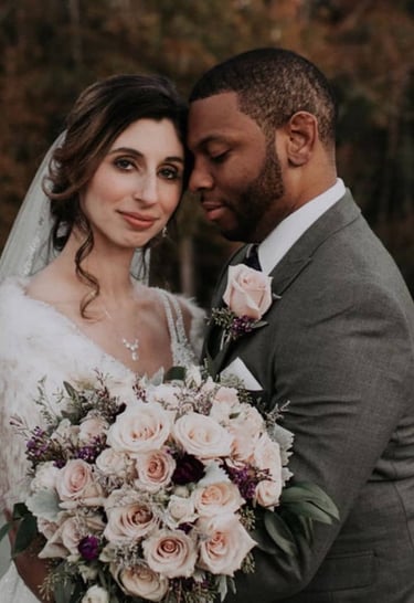 Bride and groom with beautiful pink rose bouquet, and stunning wedding hair and wedding makeup