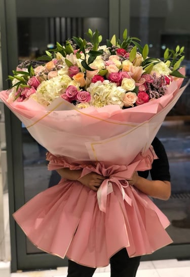 a woman holding a giant bouquet of flowers 