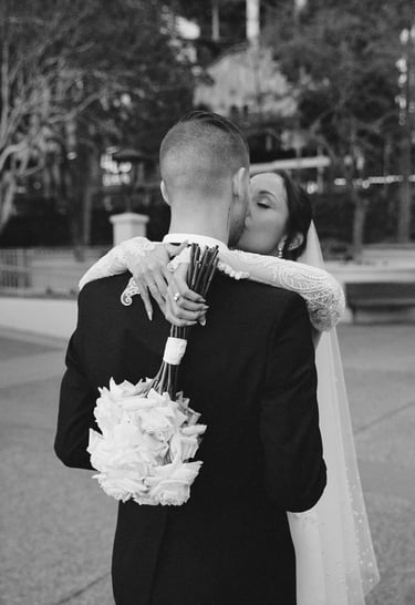 a bride and groom kissing in a city