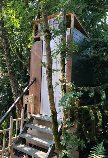 steps up to a wooden building housing a compost toilet