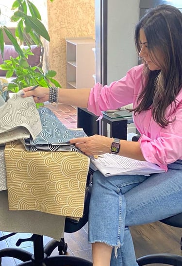 Sigal, founder of Solo Home Decor, selects fabrics while designing custom furniture.