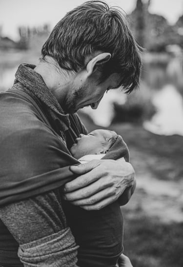 Un père porte son bébé en écharpe et le regarde avec amour, Zohra Elmes