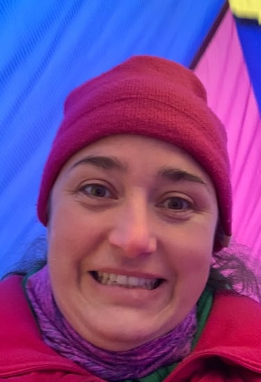 Kayla Brooks standing between hot air balloons and looking excited