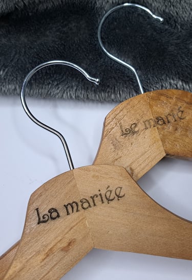 a wooden hanger with a pair of clothes hangers