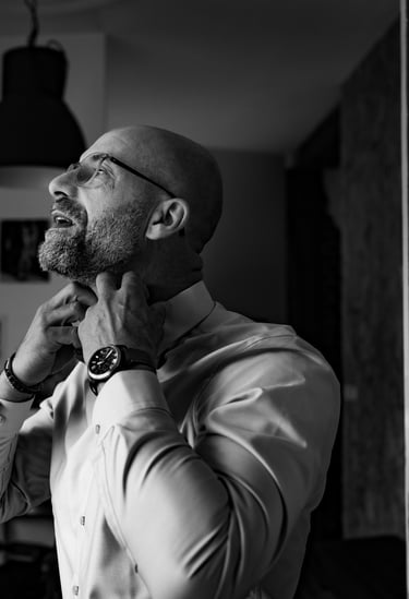 Un homme en chemise blanche remettant son col