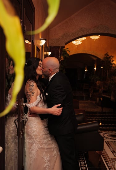 a wedding Couple kissing in a hotel lobby