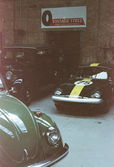 a classic car garage with three vintage cars parked in it