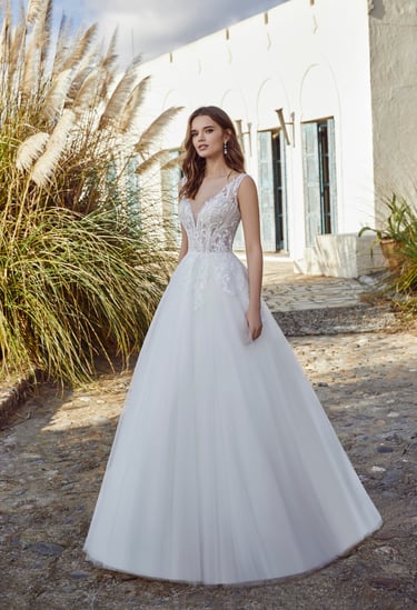 a woman in a white wedding dress standing in front of a house