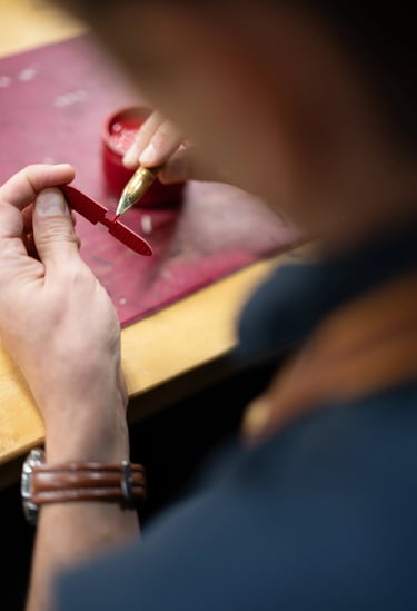 Application à la main de teinture sur la tranche d'une tirette en cuir