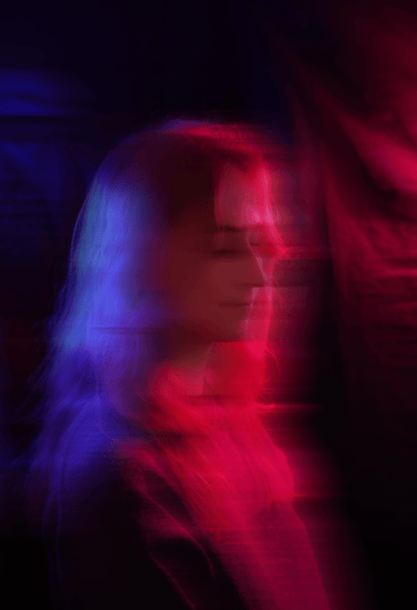 portrait d'une vidéaste avec des jeux de lumière rose et bleu