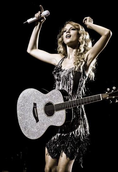 Taylor Swift performing with sparkly guitar at Fearless Tour 2009 concert in the USA.