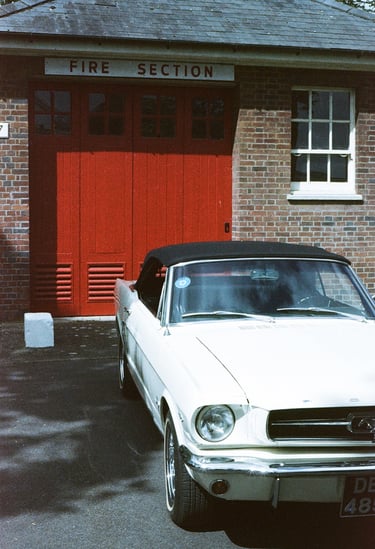 a classic Ford Mustang parked in front of a brick building