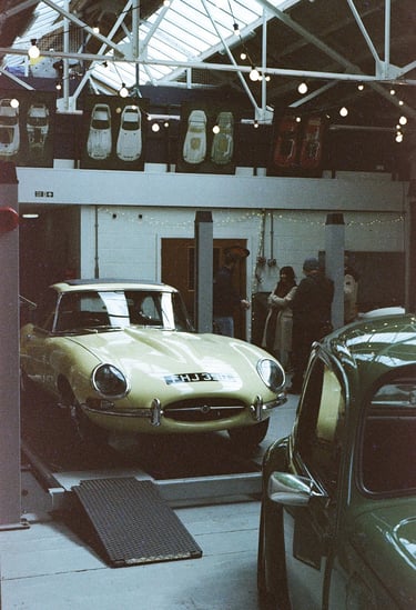 a classic car garage with two vintage cars parked in it