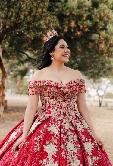 Hermoso retrato profesional de quinceaños con vestido rojo en Itchimbía Quito con naturaleza y sonrisa de felicidad
