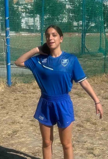 a woman in a blue shirt and shorts playing soccer