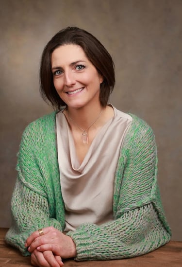 Seated  portrait Louise Mac Sweeney Funeral celebrant Green cardigan