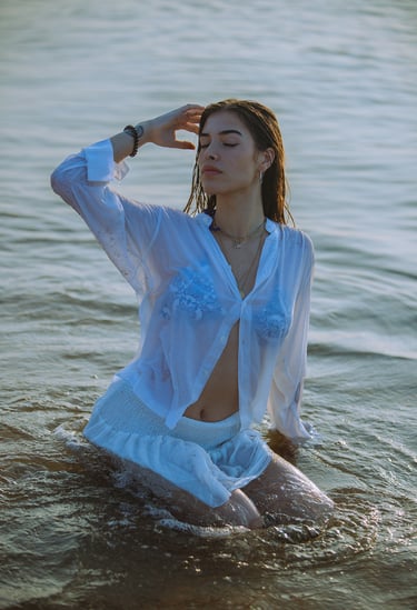 Sesión de fotos de revista con modelo en la playa al amanecer, vestido blanco y bikini
