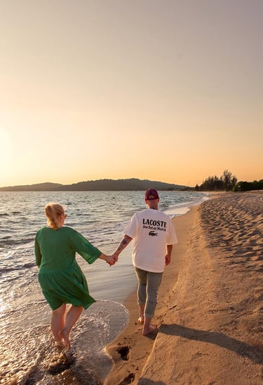 Couple walking along the shoreline at sunset during a family photoshoot at Mövenpick Resort Phu Quoc
