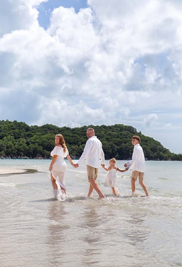 Family walking through shallow water on Khem Beach