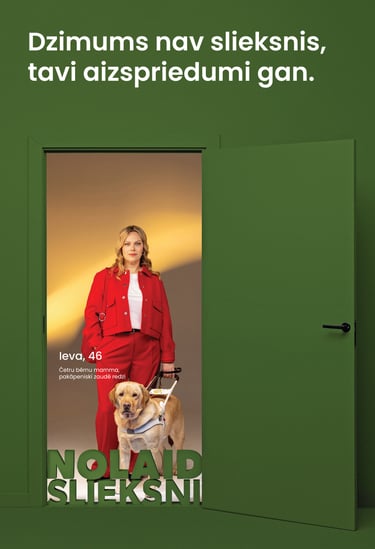 Sieviete ar suni pavadoni atvērtās durvīs. Teksts: Dzimums nav slieksnis, tavi aizspriedumi gan.