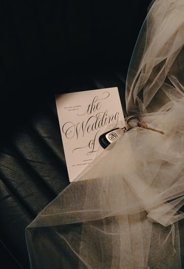 Image of the interior of a 1958 MG MGA Roadster with a wedding invitation a set of keys.