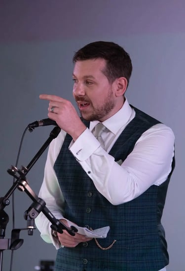 Groom in a green plaid vest delivering a speech.