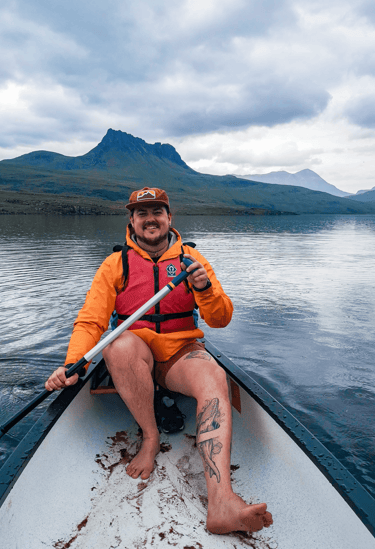 sam rayes creative smiling whilst paddling on a lake