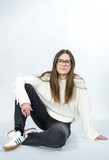 a woman in glasses and a white sweater