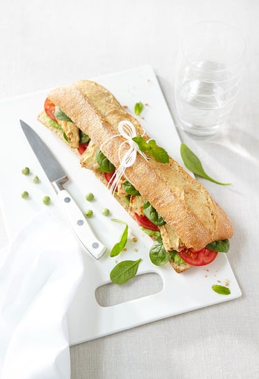 a sandwich sandwich on a cutting board with a knife and knife