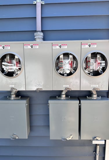Milbank outdoor electrical meter sockets and disconnect boxes installed on blue siding.