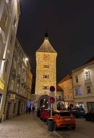 The illuminated Ledererturm tower in Wels, Austria, at night during the Christmas market season, sur
