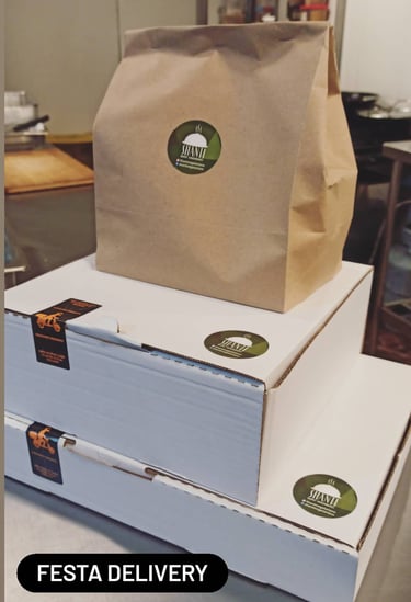 a box of pizzas with a brown paper bag