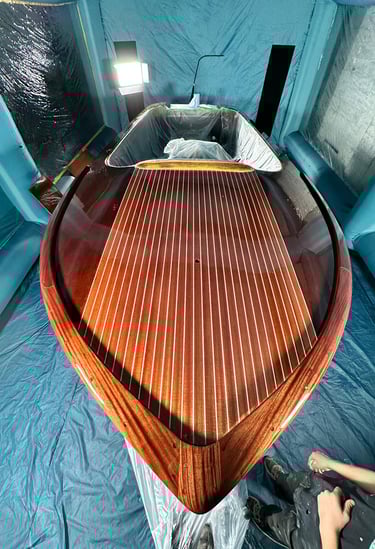 a man is painting a wooden boat in a boat