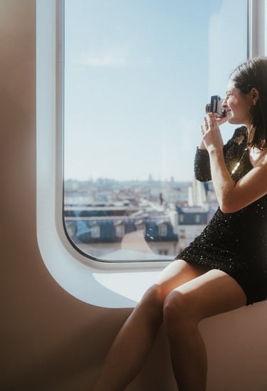 Femme qui prend des photos depuis sa chambre de l'hôtel Renaissance Paris République