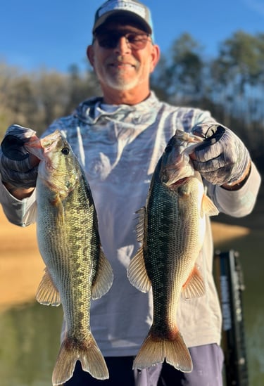 holding two largemouth fish
