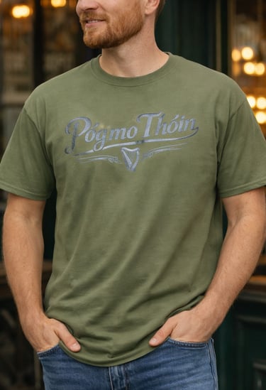 A man wearing an olive green Póg Mo Thóin t-shirt with a silver harp logo.