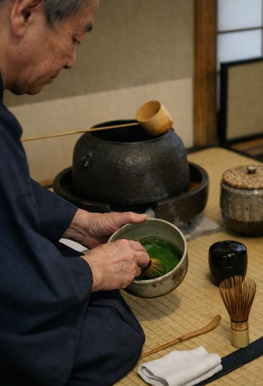 A Japanese tea master whisking matcha green tea in a ceramic bowl during a traditional ceremony.