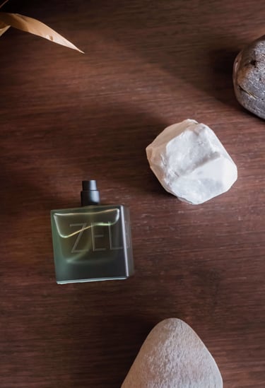 a bottle of perfume on a table with rocks