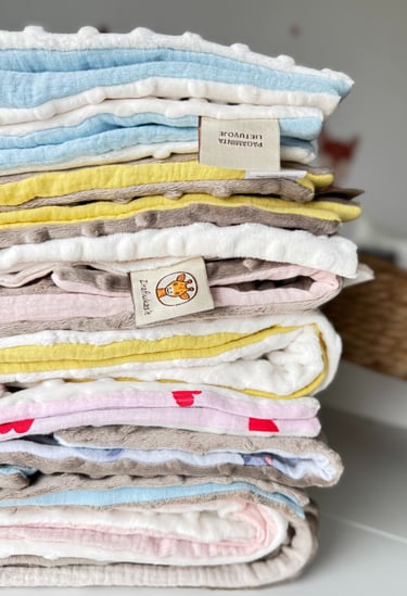 įvairių spalvų vaikiškų pledukų rinkinys