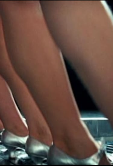 Homage scene from Ken Russell’s The Boy Friend (1971) with silver‑shoed dancers in wide‑leg stance.