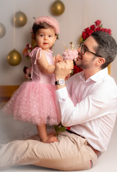a man and a little girl in a pink dress