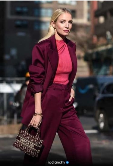 a woman in a pink sweater and pantsuituit with a handbag