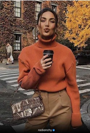 a woman in a turtle neck sweater and pants