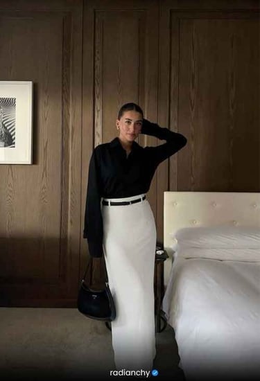 a woman in a white skirt and black shirt