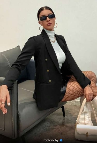 a woman in a black jacket and fishnet stockings